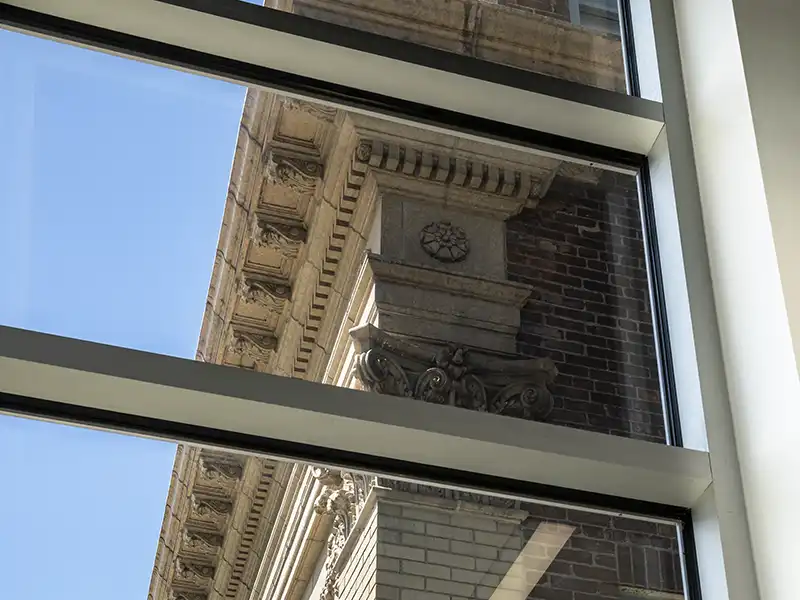 Looking through a modern window to the exterioro of an older building