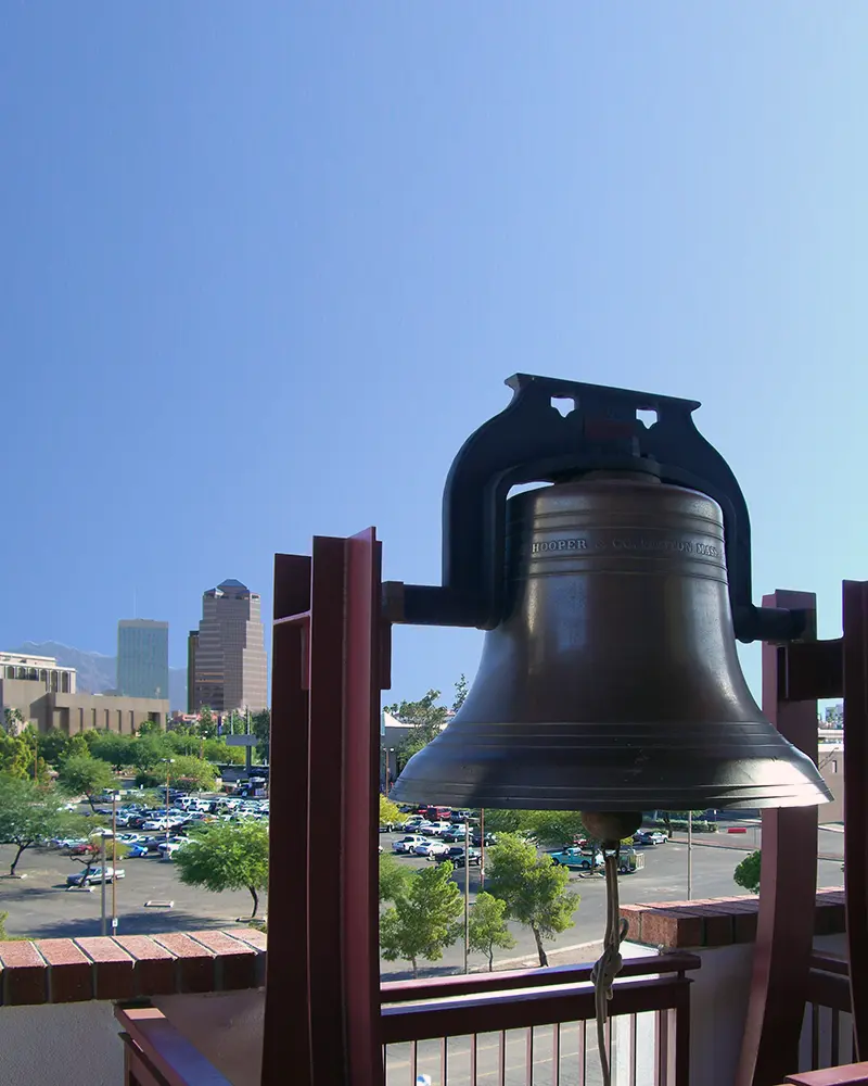 Bell in foreground, Tucson skyline in background