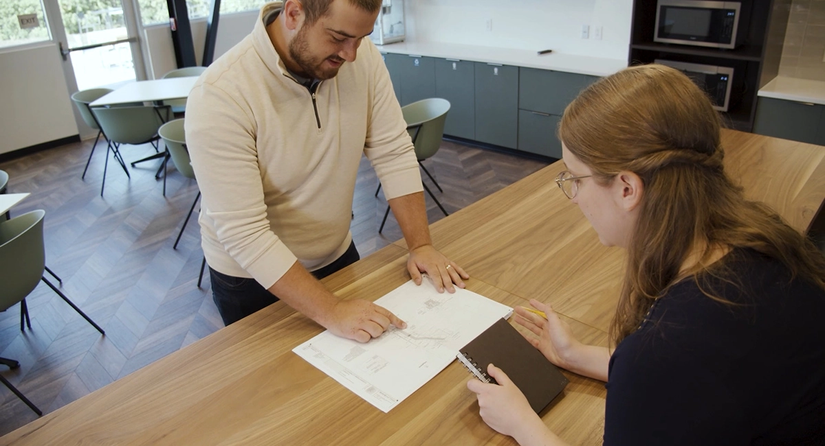 A man and a woman collaborating over design document.