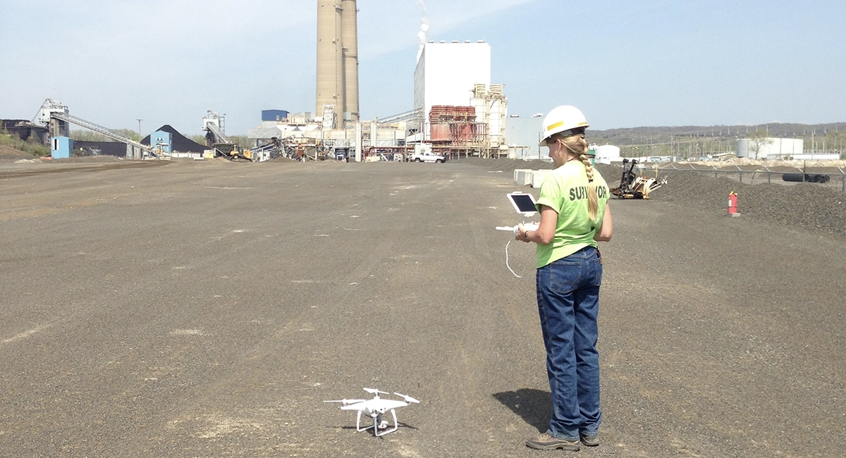Surveyor using drone on survey site.