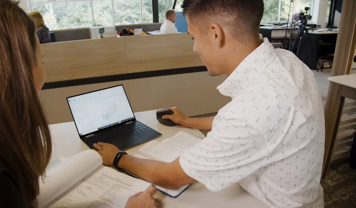 Two people working with laptop on model