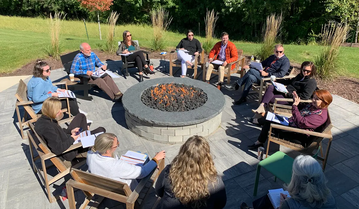 Group of architects and engineers learning around firepit