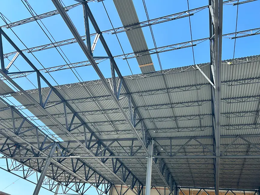 Close-up of steel roof structure with partially installed metal panels.