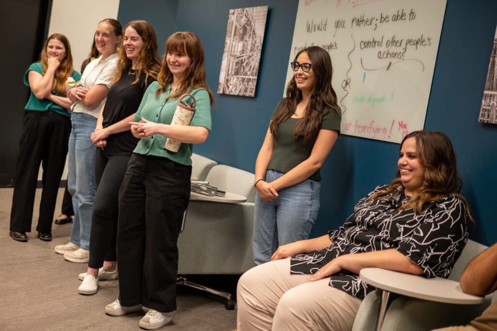 Shive-Hattery Quad Cities coworkers smile while watching a colleague try the KI chair