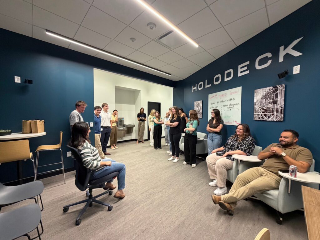 A coworker tests the KI chair while Quad Cities colleagues look on