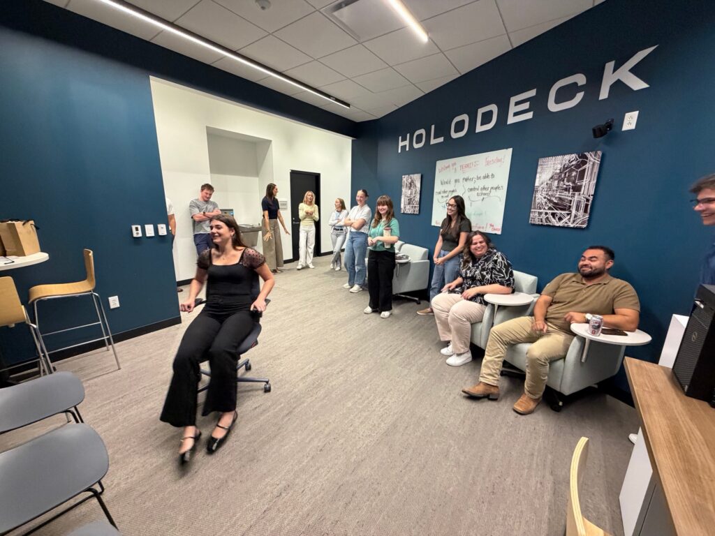 A coworker laughs while trying the KI chair in the Holodeck at Shive-Hattery Quad Cities