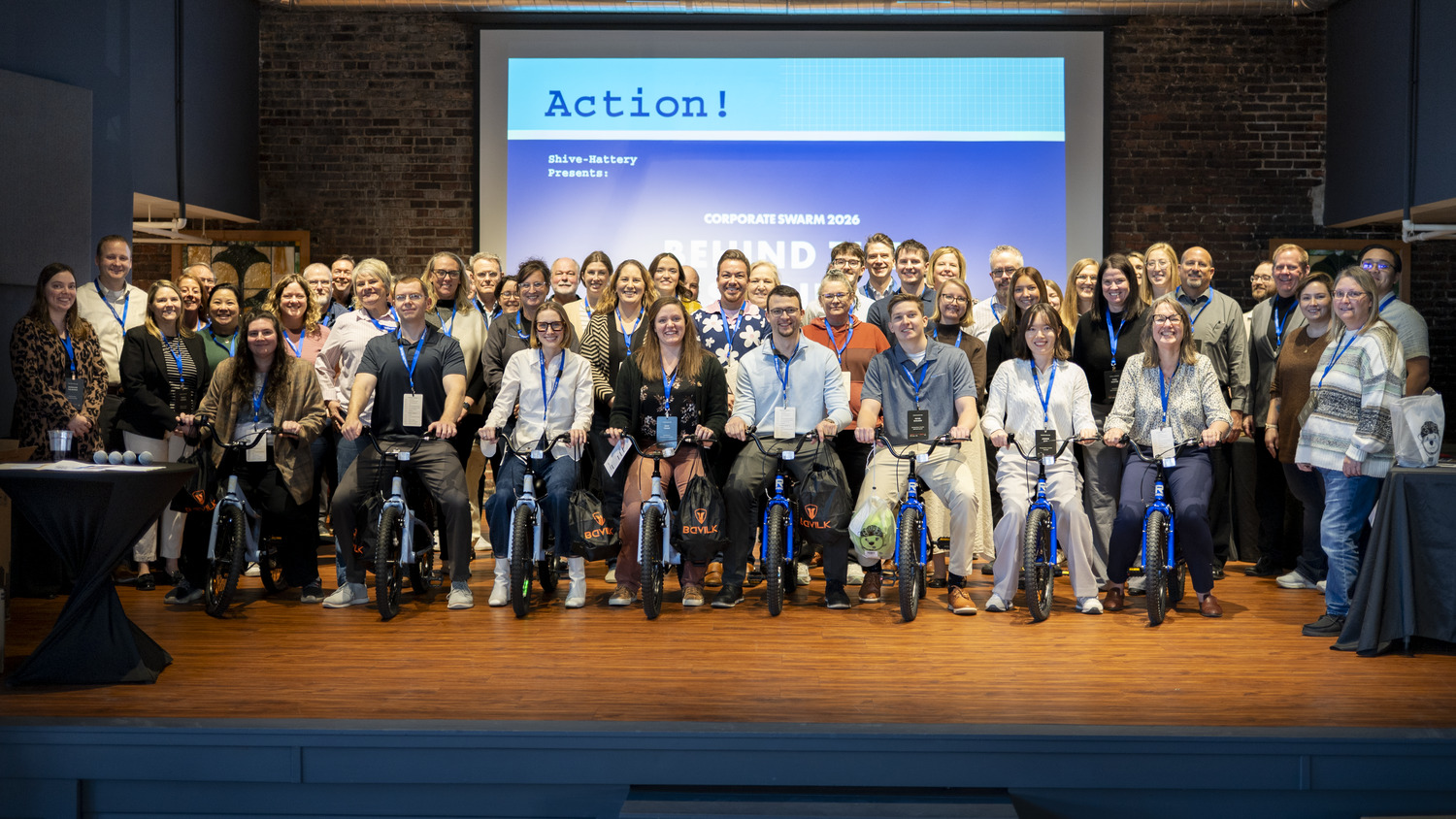 Shive-Hattery corporate team gathered on stage with bicycles during the 2026 Corporate Swarm